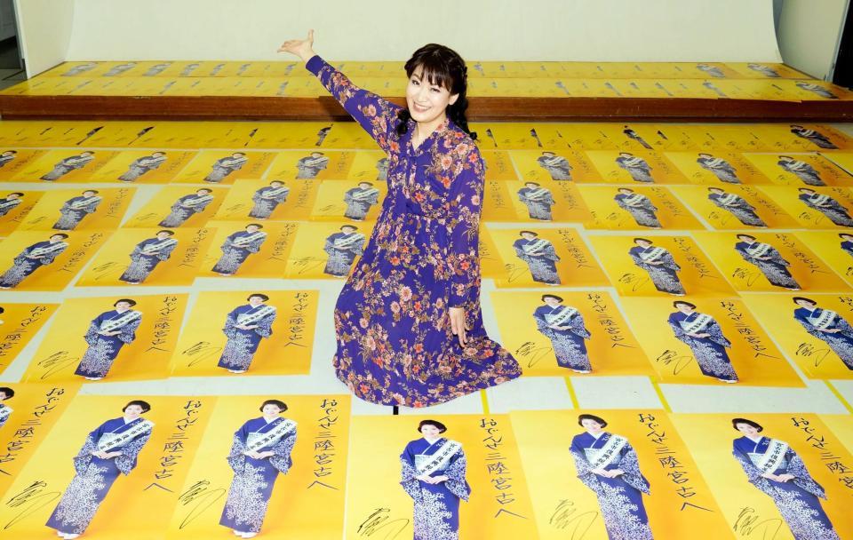 サインした１５００枚のポスターを前に笑顔を見せる市川由紀乃＝都内