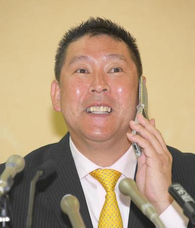 記者会見を前に携帯電話を使って話し込む立花孝志氏＝都庁（撮影・堀内翔）