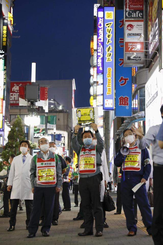　「東京アラート」の発令期間中に、新宿・歌舞伎町で注意喚起する東京都の職員ら＝５日夜
