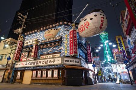 　大阪・新世界のふぐ料理店「づぼらや」。後方は緑色にライトアップされた通天閣＝１１日夜