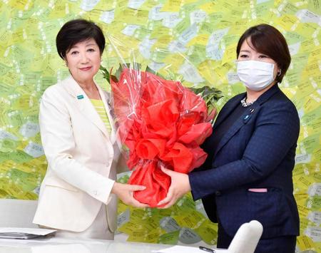 東京都知事選で再選を果たし、関係者から花束を受け取る小池百合子氏（左）＝５日夜、東京都新宿区