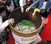 　広島カープの新球場建設へ向け「たる募金」にお金を入れる人々＝２００４年１１月