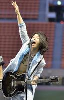 ギターを演奏するＭＩＹＡＶＩ。胸元には「不退転」の漢字タトゥーが(２０１３年)