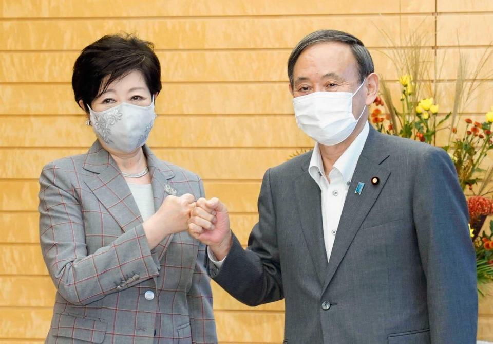 　グータッチを交わす菅首相（右）と東京都の小池百合子知事＝首相官邸