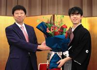 　師匠の杉本昌隆八段（左）から花束を受け取る藤井聡太王位（代表撮影）