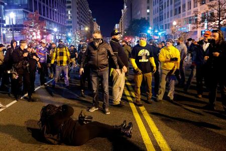 　米ワシントンで親トランプ大統領派の大規模集会後の衝突の最中、地面に横たわる女性（ロイター＝共同）