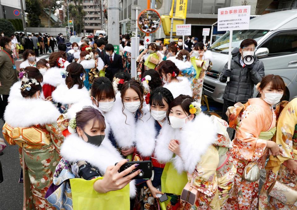 　杉並区の成人式会場前で記念撮影する新成人。終了後の会食や宴会を控え、すぐに帰宅するよう呼び掛けられた