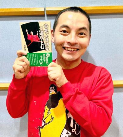 　本を手に笑顔を見せる三遊亭とむ