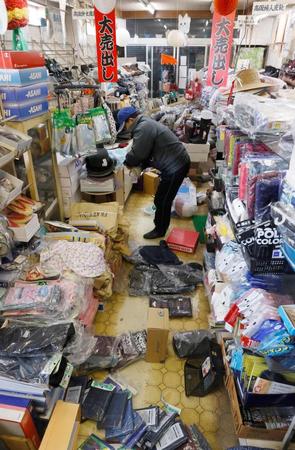 地震で散乱した商品を片付ける履物店の店主＝福島県国見町