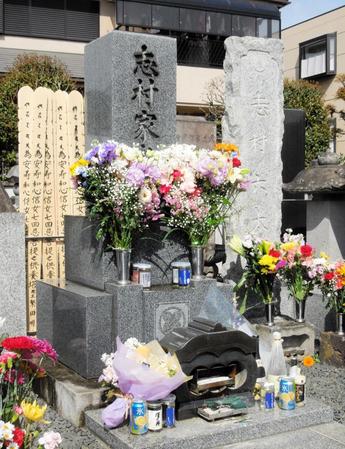　たくさんの花やカップ酒が供えられた志村けんさんの墓