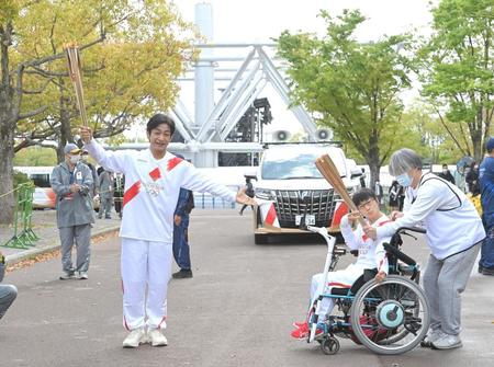 聖火リレーを行い、トーチキスをする片岡愛之助（左）＝撮影・高部洋祐