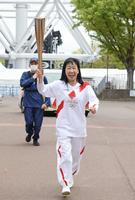 聖火を手に笑顔で走るハイヒールのリンゴ（代表撮影）