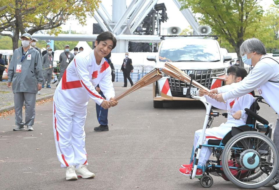 聖火リレーを行い、トーチキスをする片岡愛之助（左）＝撮影・高部洋祐