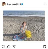 結婚を報告した岡田ロビン翔子のインスタグラムより。ビーチで花束を手に幸せいっぱいの笑顔