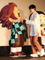 　声を担当した竈門炭治郎とハイタッチを交わす花江夏樹＝東京・日比谷