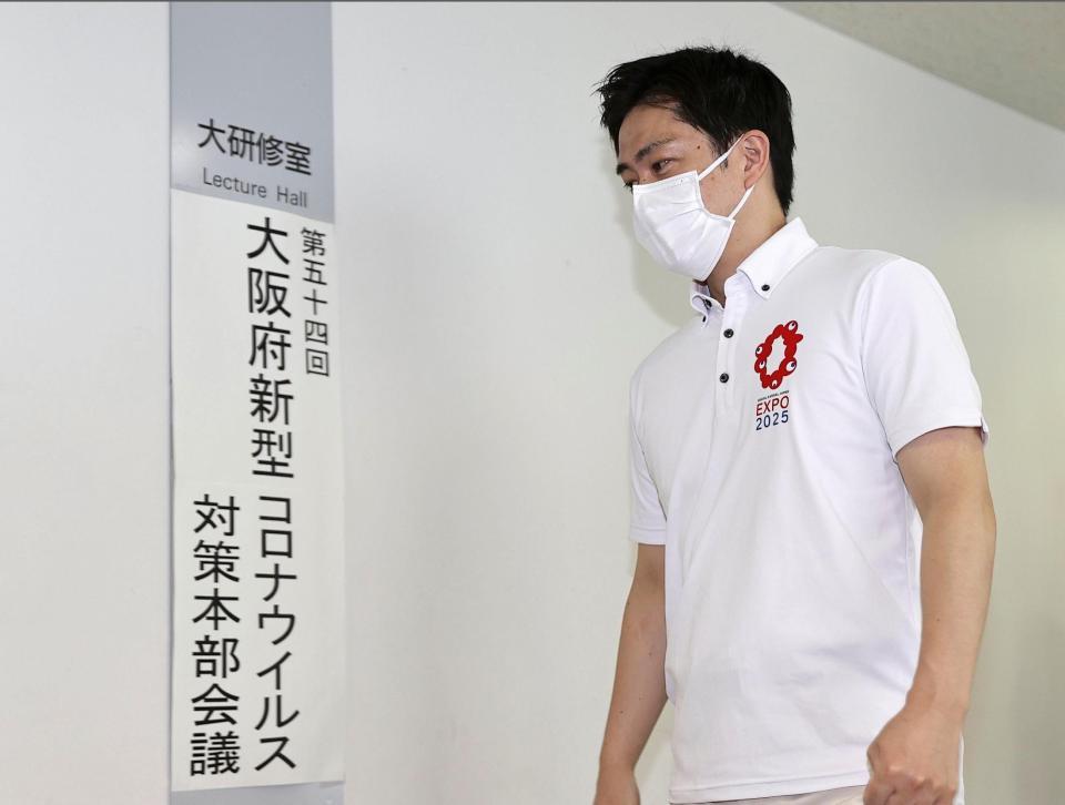 　大阪府の新型コロナウイルス対策本部会議に向かう吉村洋文知事＝７日午前、大阪市