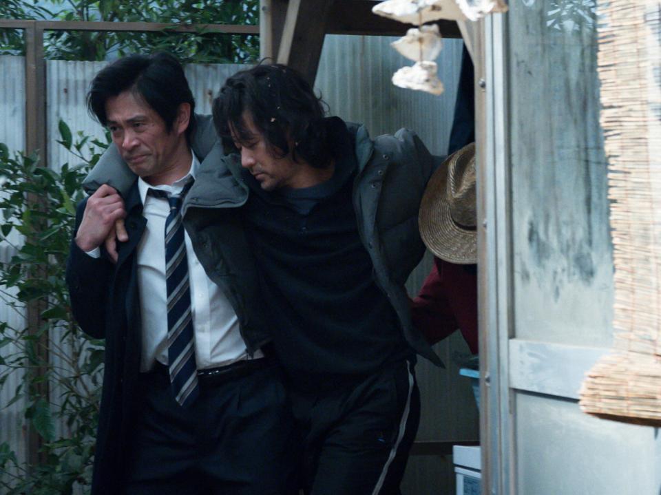 酔いつぶれていた新次（浅野忠信・右）の肩を抱える耕治（内野聖陽）