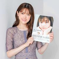 　卒業記念写真集を手にする松村沙友理