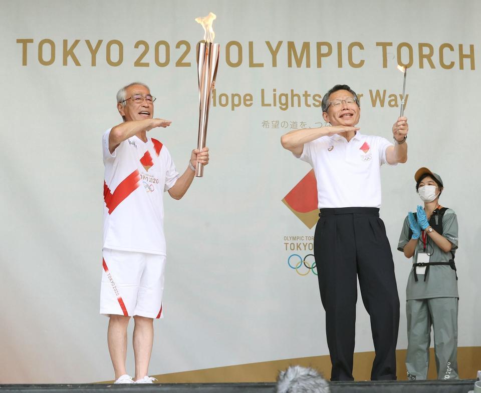 トーチを手に「アイーン」のポーズをする志村知之さん（左）＝東京都東村山市（代表撮影）