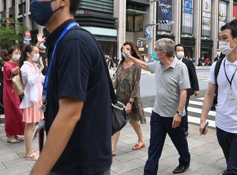 　通行人に声をかけられ、手を振り返すＩＯＣ・バッハ会長（右）＝東京・日本橋（撮影・高石航平）