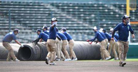 　２０日の試合前、グラウンドのシートを取り除くスタッフ（撮影・北村雅宏）