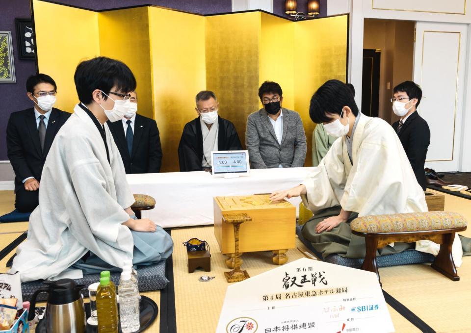 対局前に駒を並べる藤井聡太二冠。左は豊島将之叡王＝名古屋市（日本将棋連盟提供）