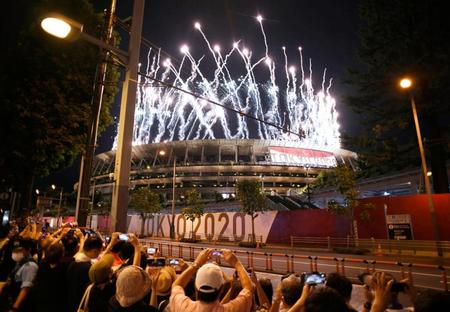 東京パラリンピックが開幕し、国立競技場で打ち上げられた花火。無観客で行われた会場周辺では撮影する人たちの姿があった＝24日夜