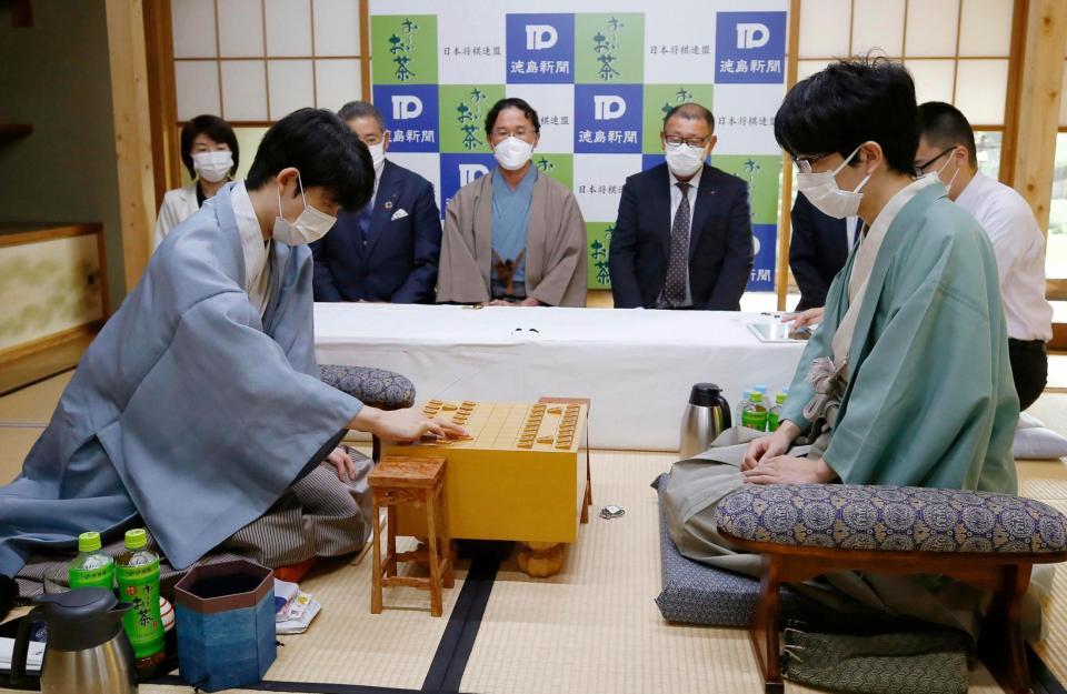 初手を指す藤井聡太王位。右は豊島将之竜王＝徳島市（代表撮影）