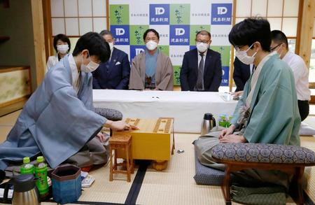 　初手を指す藤井聡太王位。右は豊島将之竜王＝徳島市（代表撮影）