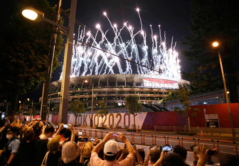 　国立競技場で打ち上げられた花火を沿道から撮影する人たち