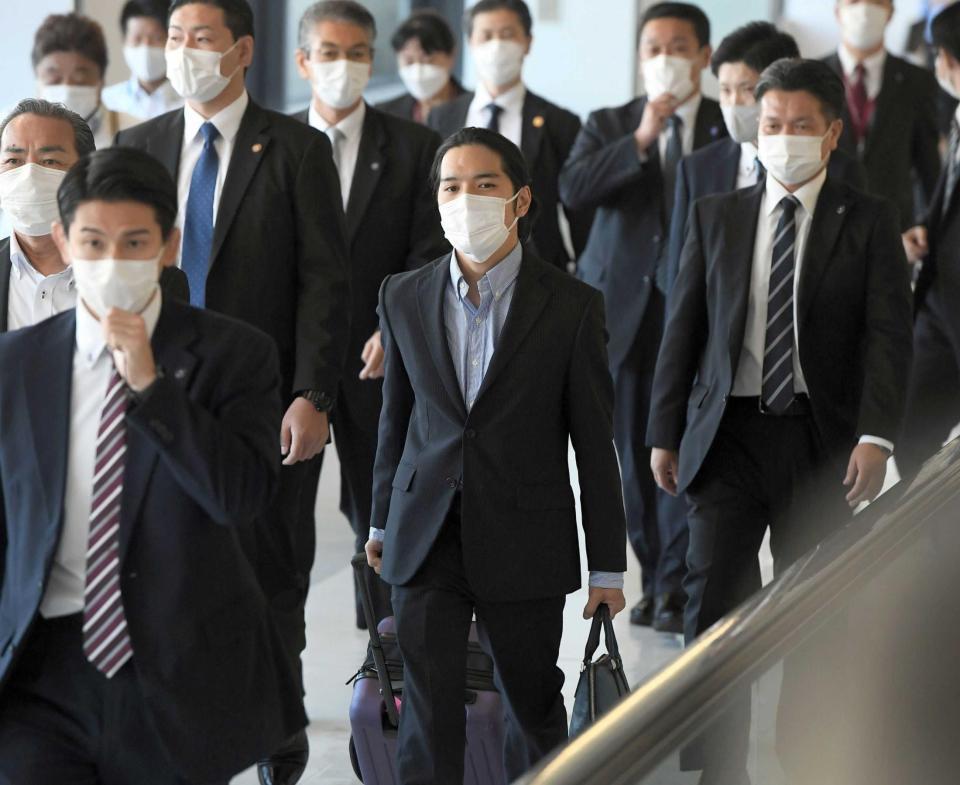 　米国から帰国し、ＳＰたちに囲まれて歩く小室圭さん（中央）　