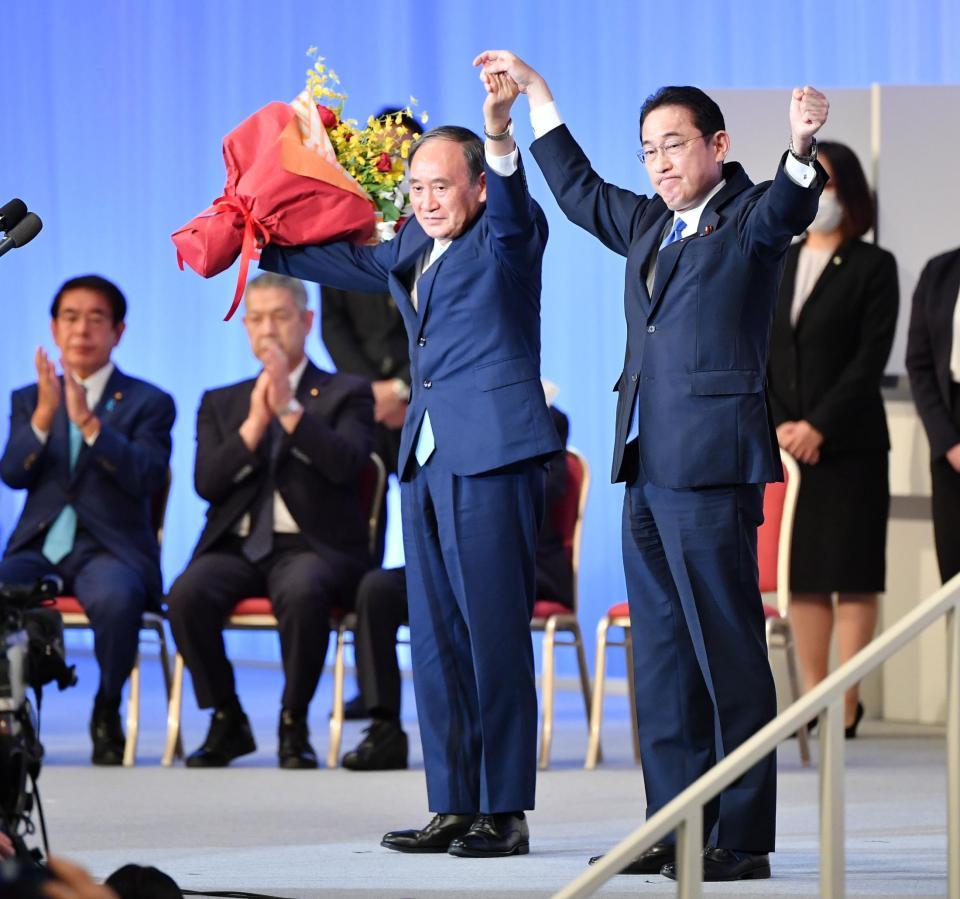 　菅義偉首相（左）と並んで両手を上げる岸田文雄自民党新総裁＝東京・グランドプリンスホテル新高輪（撮影・西岡正）