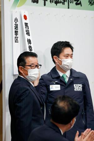 　開票センターで当確者の名前を張る日本維新の会の松井代表（左）と吉村副代表＝大阪市内のホテル