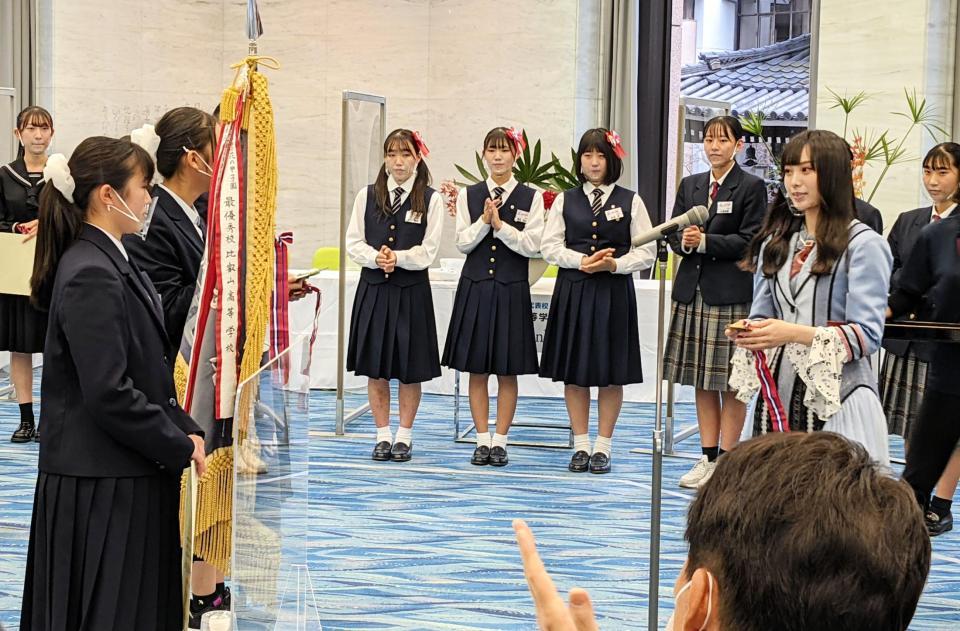 　「花の甲子園２０２１」に優勝し、大会アンバサダーのＮＭＢ４８・梅山恋和（右）からメダルを贈呈される岐阜県立岐阜商業高校のメンバー