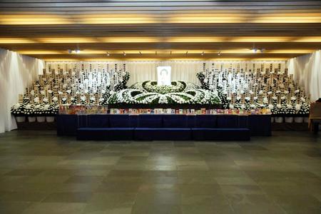 　祭壇は菊で形作られ、遺影の周りには著名人から送られた花が設置された（事務所提供）