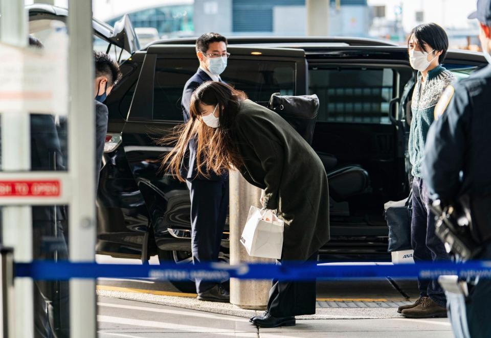 　米ニューヨークのケネディ国際空港に到着し、関係者にお辞儀する小室眞子さん（中央）。右は夫の圭さん（代表撮影・共同）