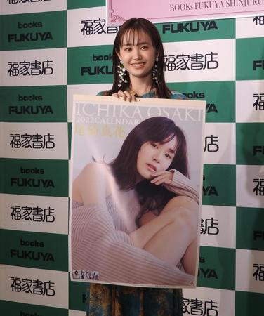 　カレンダーを手に笑顔を見せる尾碕真花＝東京・福家書店新宿サブナード店