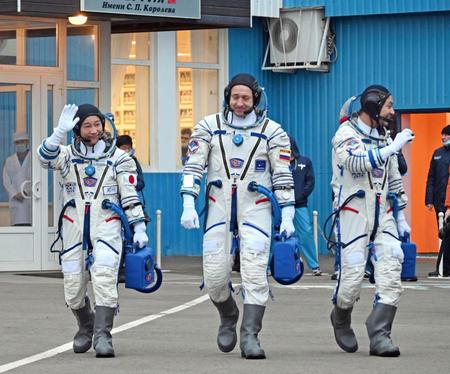 　８日、打ち上げ前に宇宙服を着用し、歩く前沢友作氏（左）ら＝カザフスタン・バイコヌール（共同）