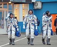 　打ち上げ前に宇宙服を着用し、歩く前澤友作氏（左）ら＝カザフスタン・バイコヌール（共同）