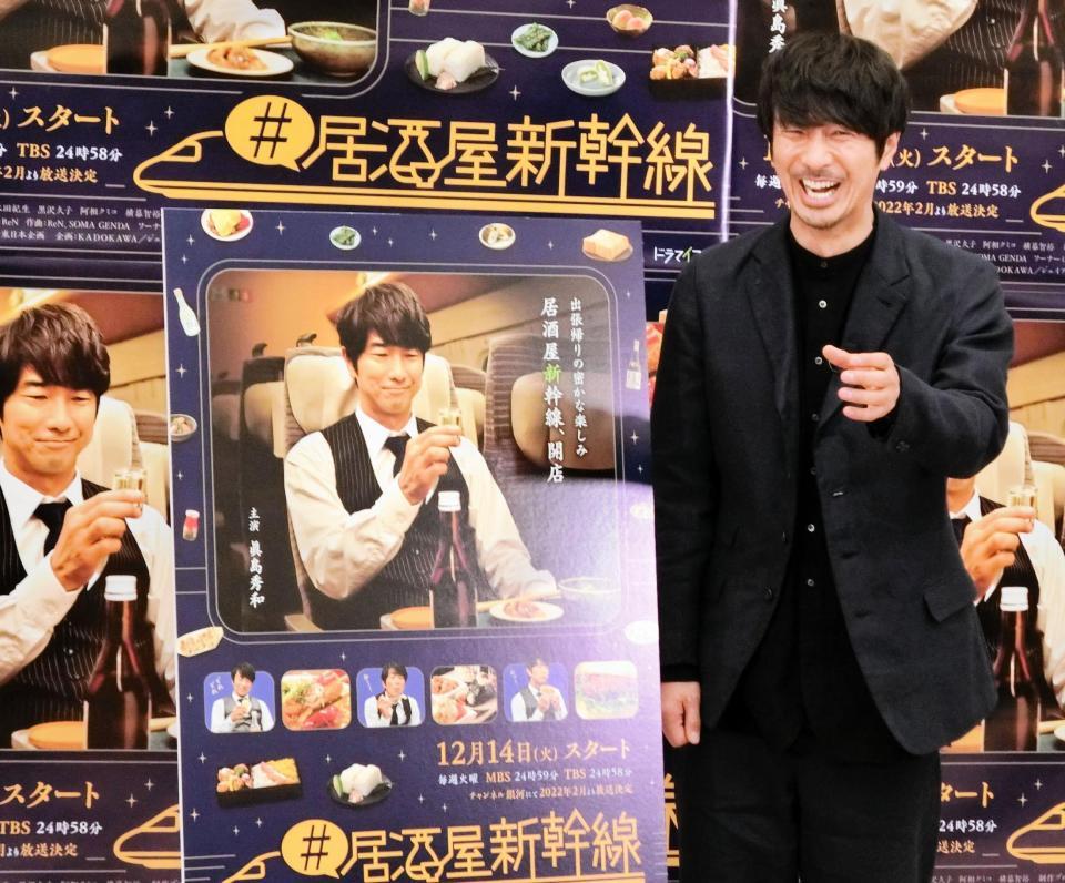 　笑顔で乾杯のポーズを決める眞島秀和