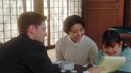 朝丘神社の社務所で、英語のテキスト作りをするロバート（村雨辰剛）と安子（上白石萌音）、娘のるい（古川凛）