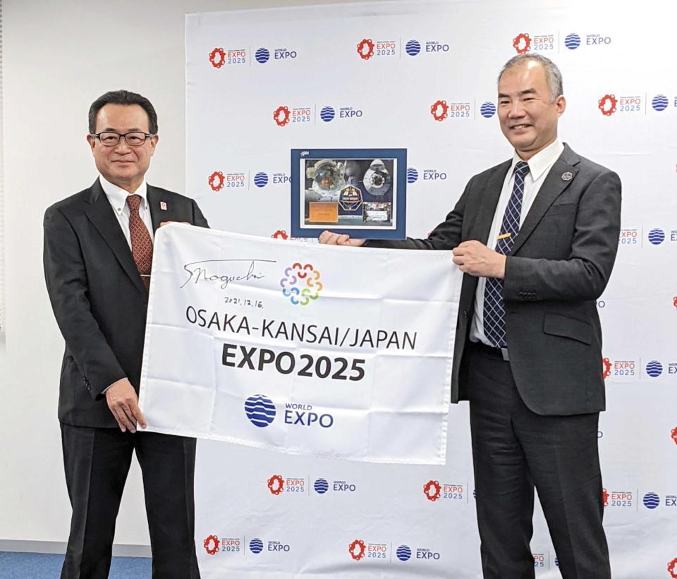 　宇宙から帰還した旗を日本国際博覧会協会に返還する宇宙飛行士の野口聡一氏（右）
