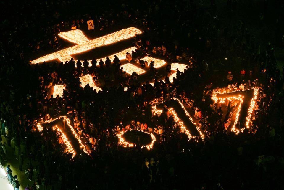 　阪神大震災から２７年となり、追悼会場に浮かび上がった「忘　１・１７」の文字＝１７日午前５時４６分、神戸市中央区の東遊園地