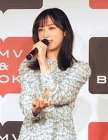 　自作のグラスを手に思いを語る小栗有以＝東京都内