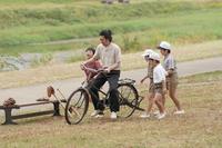 錠一郎（オダギリジョー）は賀茂川の河川敷で自転車の練習をする