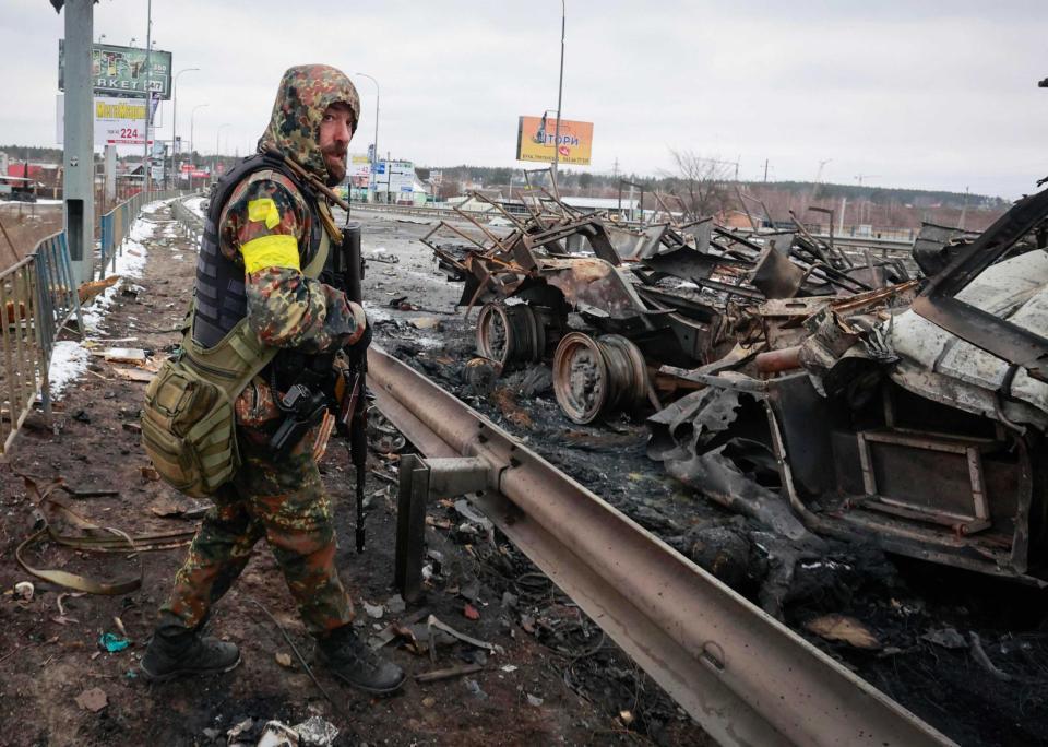 　１日、ウクライナの首都キエフ近郊で、破壊されたロシア軍の軍用車両のそばに立つ男性（ＡＰ＝共同）