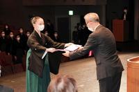 ステージで卒業証書を受け取る首席の岩永佳那子さん（左）と中西達也校長＝宝塚バウホール