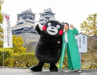 　熊本城を背にくまモンと笑顔を見せる石川さゆり