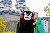 　熊本城をバックにくまモンと笑顔を見せる石川さゆり＝熊本県熊本市