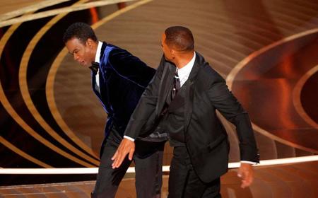 米アカデミー賞発表・授賞式で、クリス・ロックを平手打ちするウィル・スミス（右）＝27日、ハリウッド（ロイター＝共同）